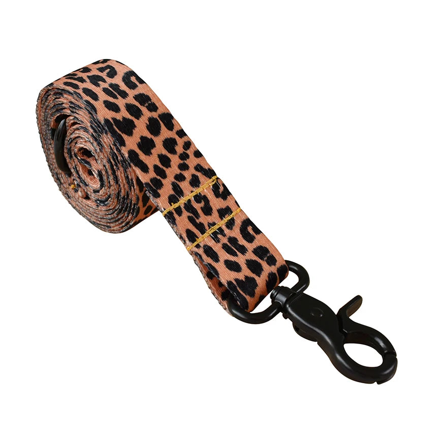 A rolled personalized printed dog collar and leash set featuring a leopard print pattern.