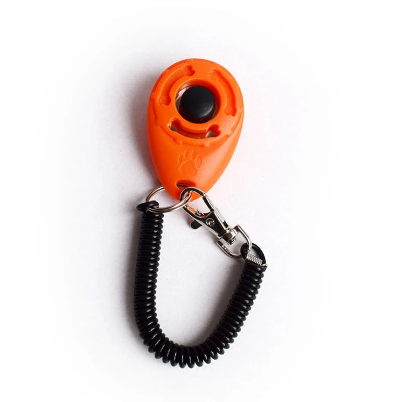 An orange pet training clicker with a black sensor attached to a metal chain and strap.