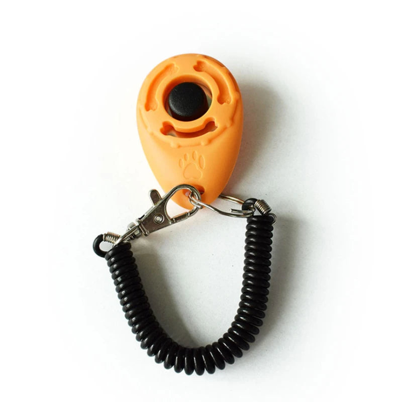 An orange pet training clicker with a black button attached to a black rubber wrist strap.