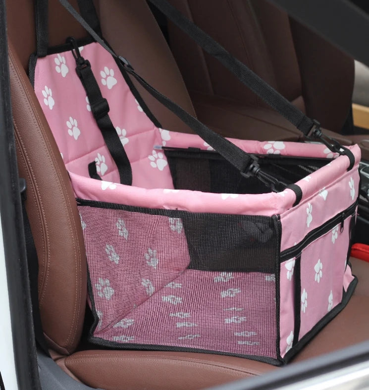 Siège voiture pliable rose et noir pour chiens montré dans un siège de voiture.