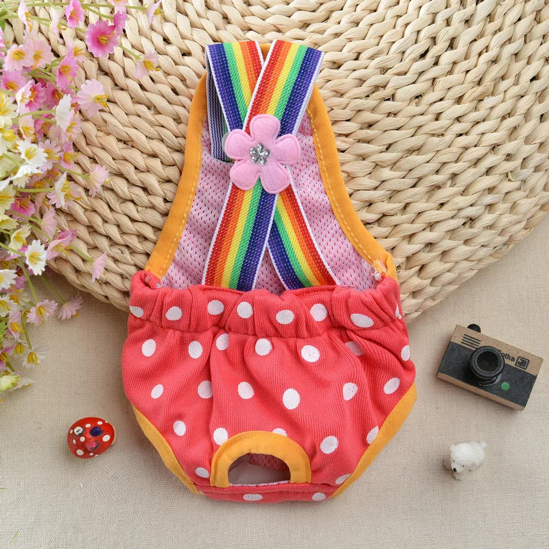A colorful washable physiological dog underwear featuring rainbow stripes and a pink flower, displayed on a woven mat.