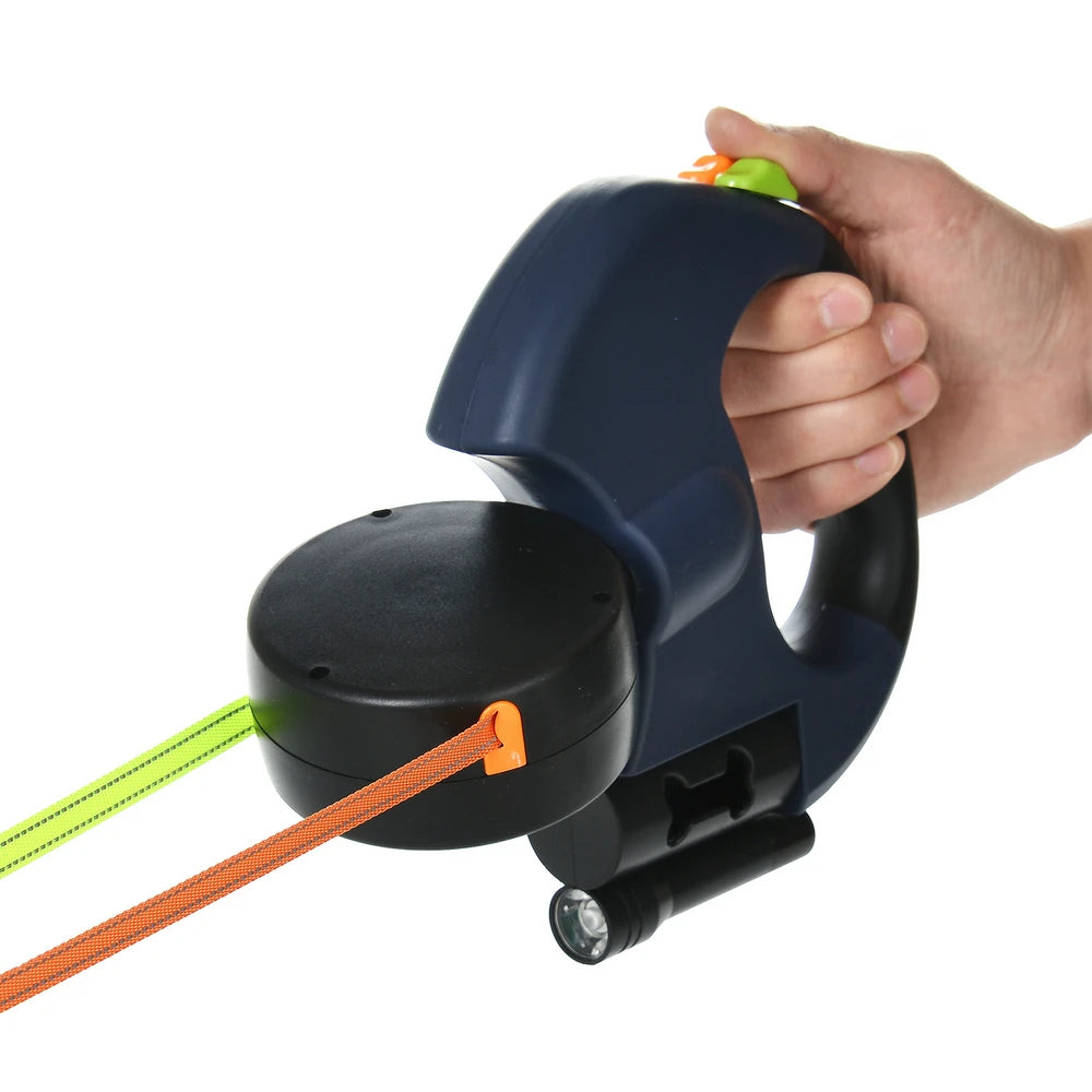 A hand is holding a dark blue retractable dog leash with an orange reflective nylon strap.