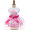 Pink lace dress for a pet featuring a bow and polka dots displayed on a mannequin.
