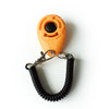 An orange pet training clicker with a black button attached to a black rubber wrist strap.