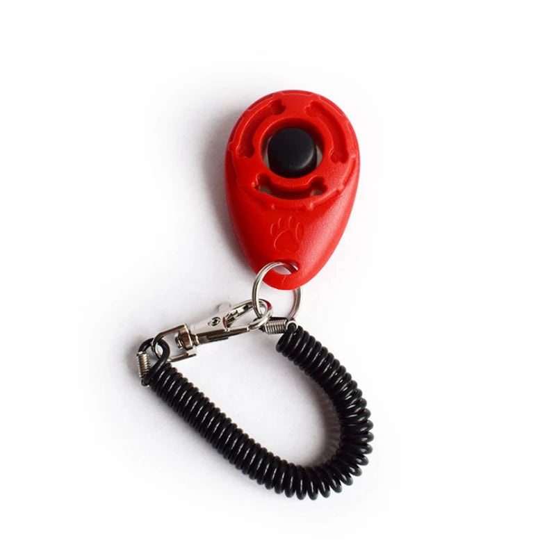 A red pet training clicker with a black button attached to a black wrist strap.