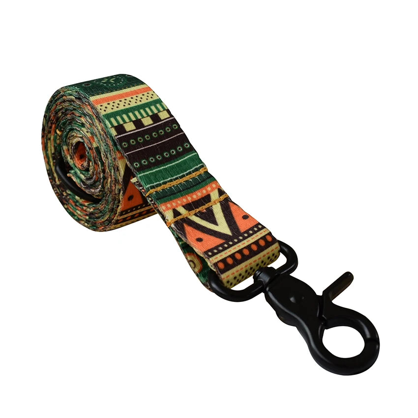 A rolled patterned fabric featuring geometric designs in green, orange, and black, used as a dog collar and leash set.