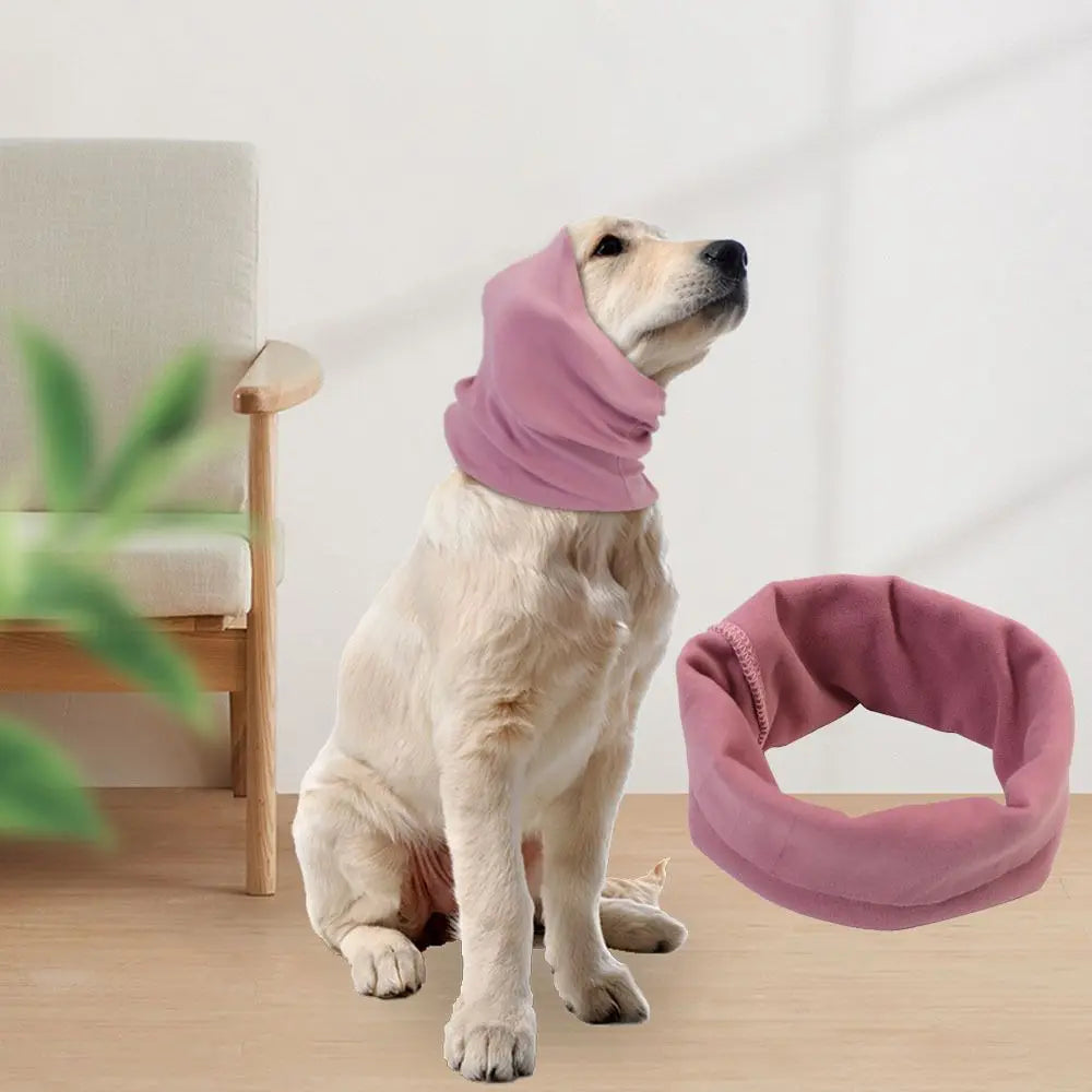 A light-colored dog is wearing a soft mauve ear muff for comfort and noise reduction.