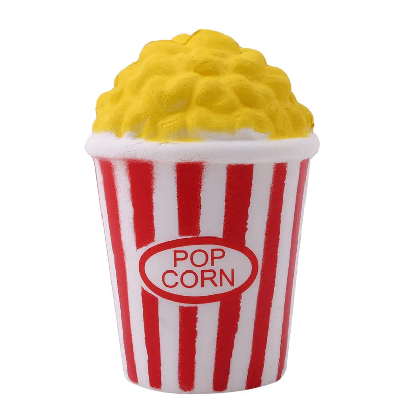 A yellow popcorn-themed squishy toy is shown in a red and white striped paper cup.