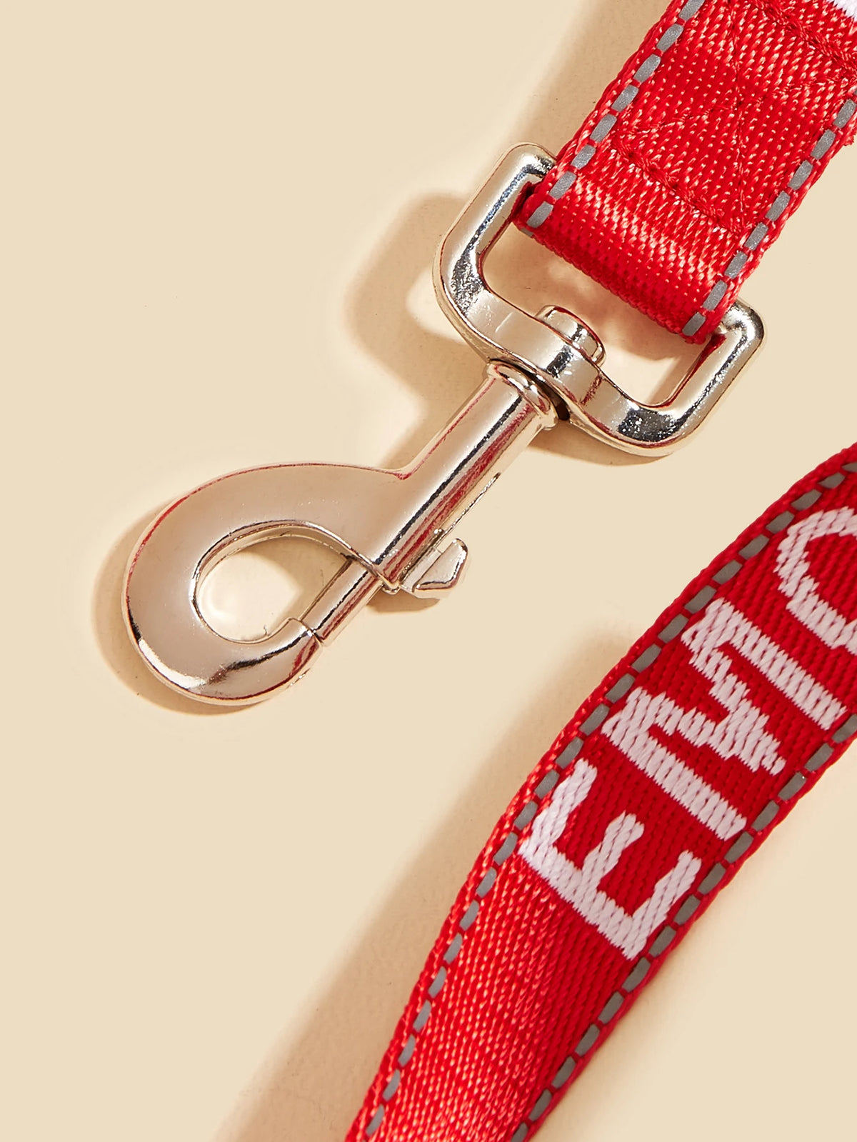 A close-up of a red reflective service dog leash with a silver metal clip and padded neoprene handle.
