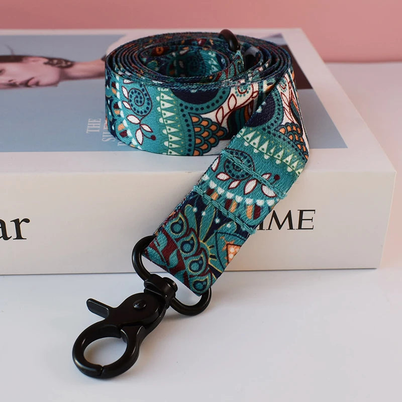 A teal patterned fabric dog collar and leash set displayed on a white box.