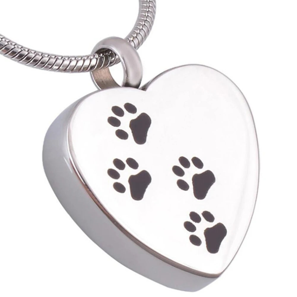 A silver stainless steel heart-shaped pet memorial necklace with four paw prints engraved on the pendant.