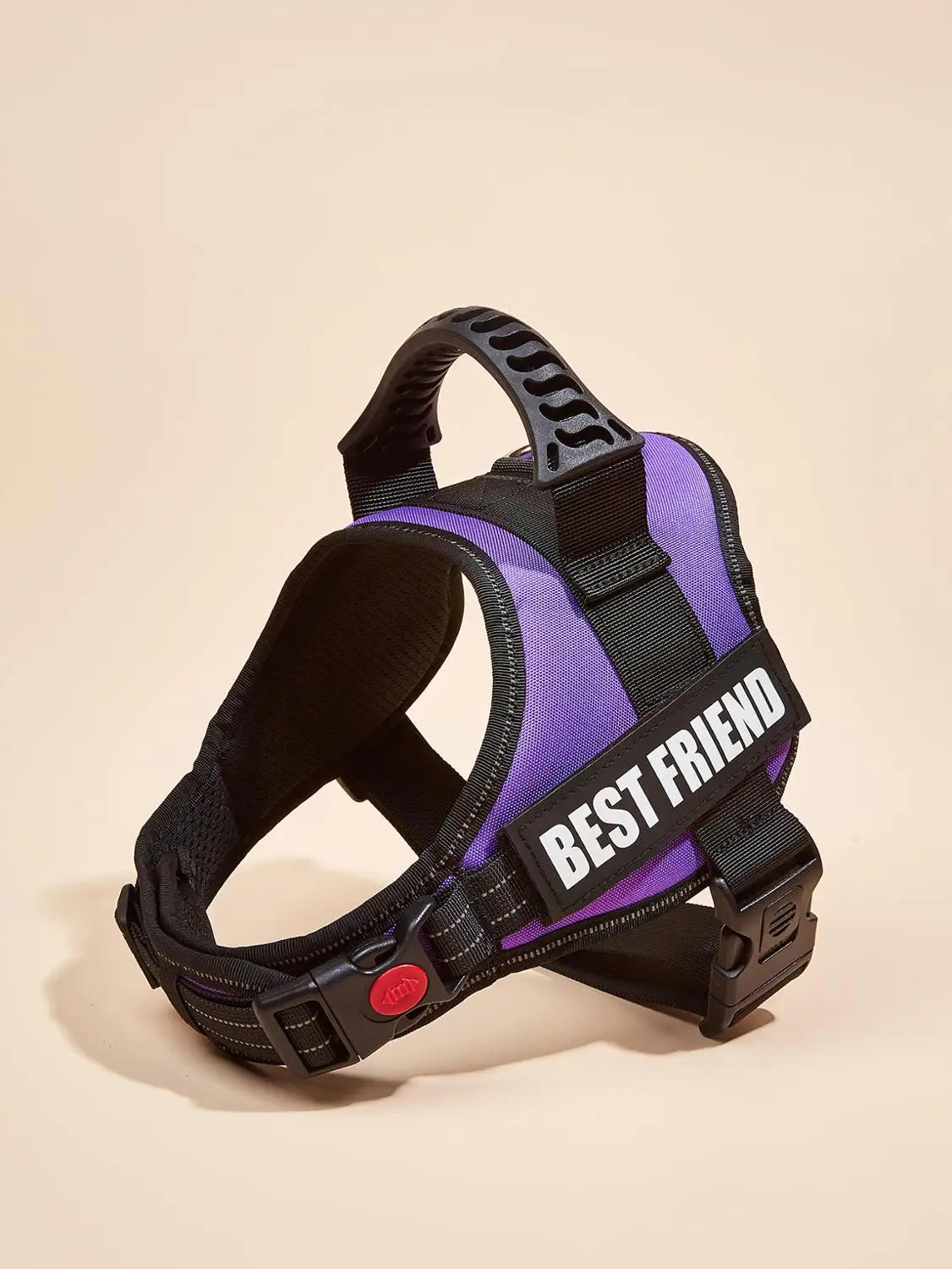 A purple and black dog harness vest with a white ID tag is shown against a light background.