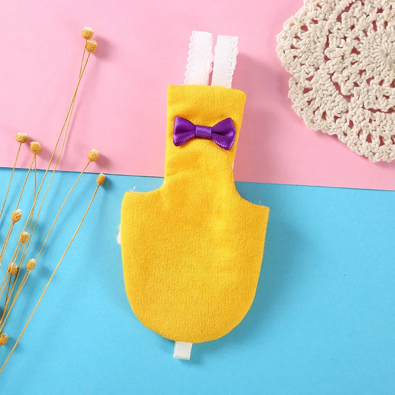 A yellow bird parrot shaped diaper with a purple bow tie and white straps against a pink and blue background.