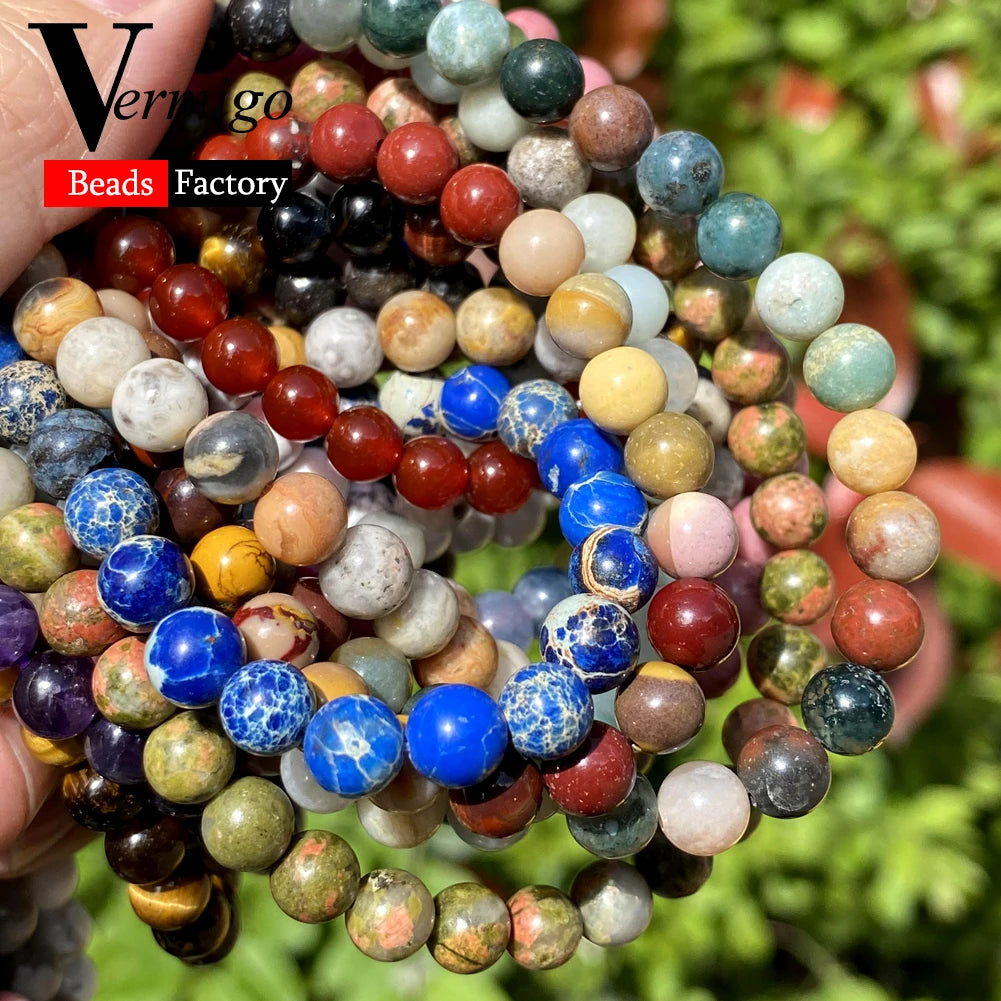 A close-up of various natural stone beads in multiple colors and sizes arranged for jewelry making.