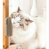 A fluffy white and gray cat is resting its head on a self-grooming massage comb mounted in a wooden frame.