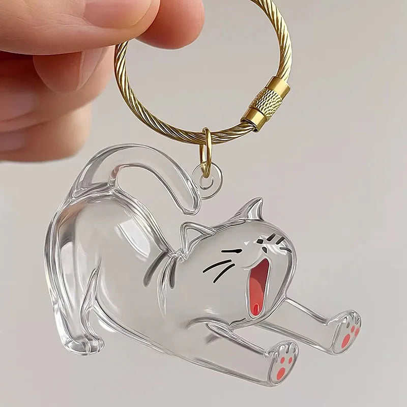 Klarer Acryl-Katzenanhänger an einer goldfarbenen Kette, gehalten von einer Hand.