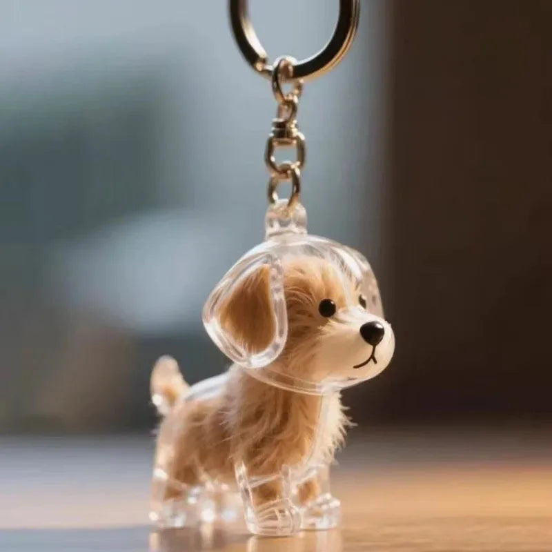 A clear silicone dog figurine keychain with a metal ring, depicting a light brown puppy.