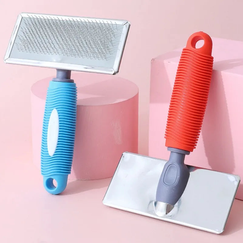 An orange silicone cat comb with stainless steel pins is shown next to a pink background.