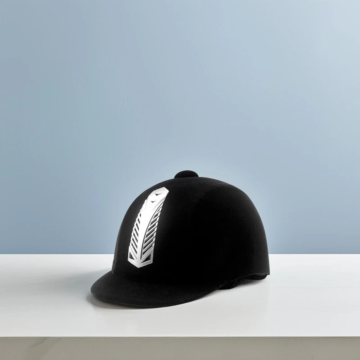 Casco de montar equino negro transpirable con hebilla ajustable sobre una superficie blanca.