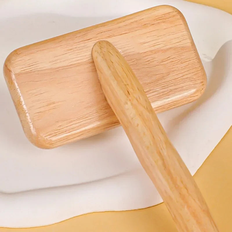A wooden pet grooming brush with massage bristles resting on a white surface.
