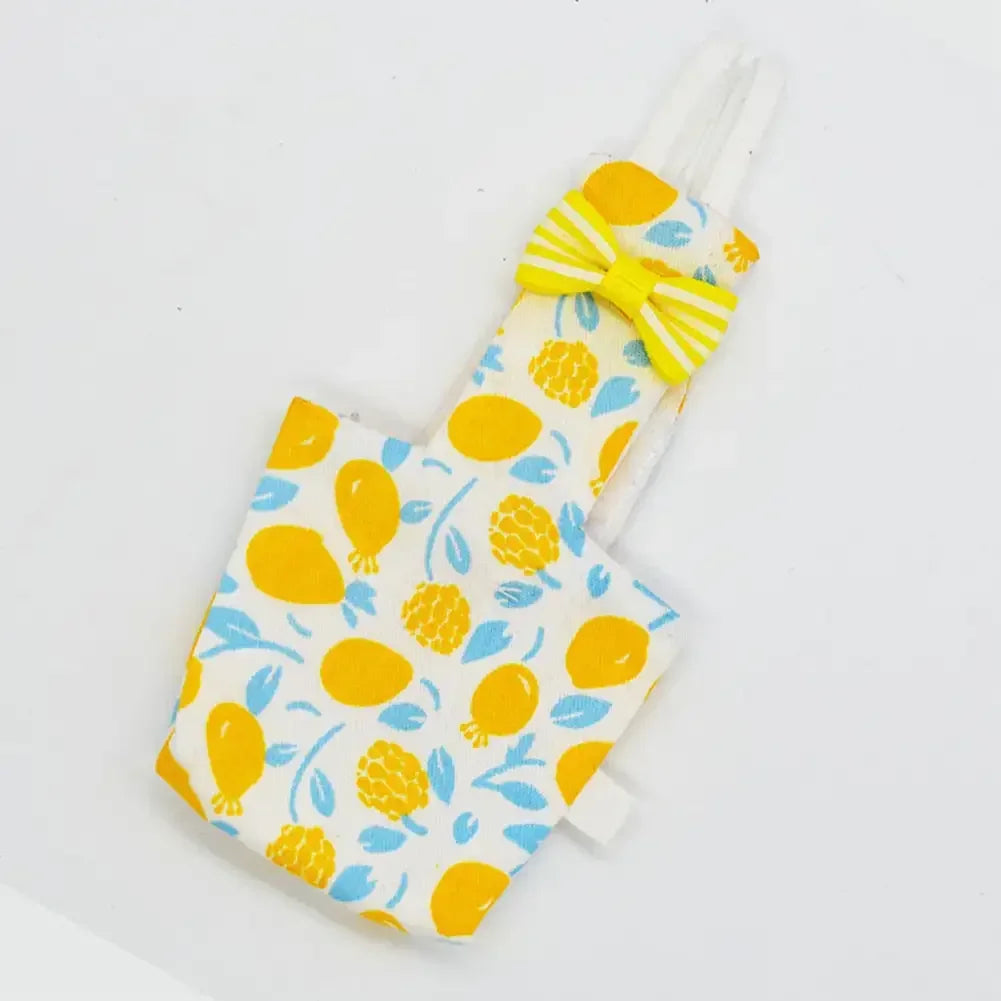 A floral parrot diaper flight suit with a yellow bow tie and white trim.