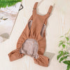 A tan dog denim jumpsuit costume for small to medium breeds lying on a light wooden surface.