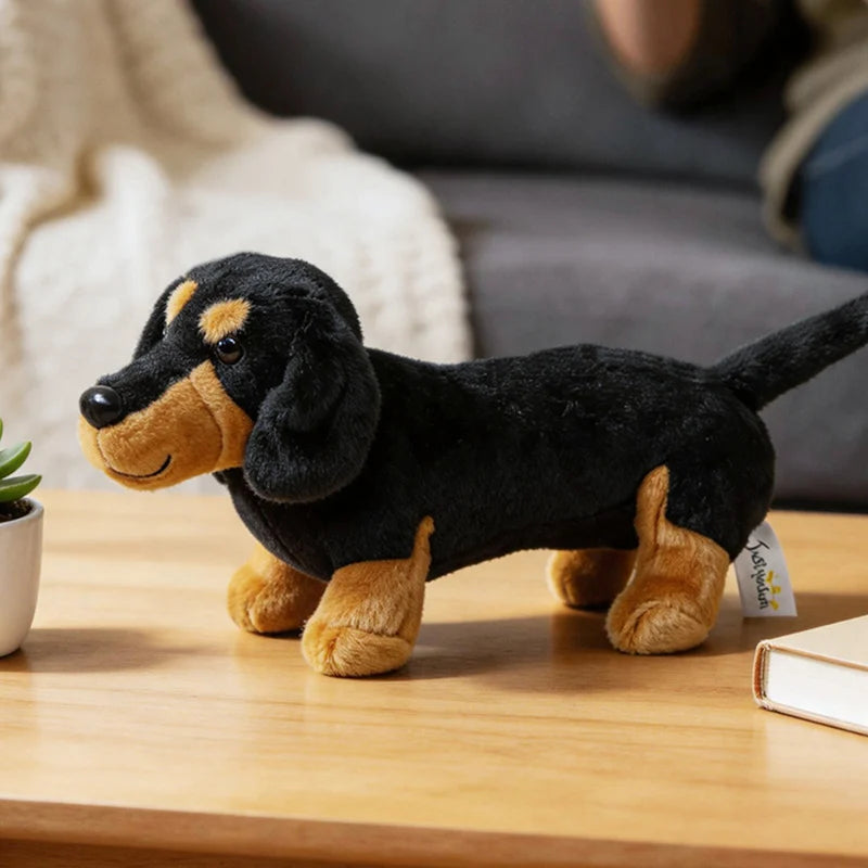 A black and tan dachshund plush toy sitting on a wooden table.
