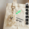 Figurine en verre clair d'un mignon chat-chien attachée à un sac en toile beige avec texte chinois.
