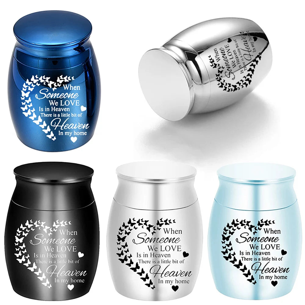 Drei Versionen einer Aluminium-Andenkippe mit Herz-Schmetterlings-Design in Blau, Silber und Hellblau.