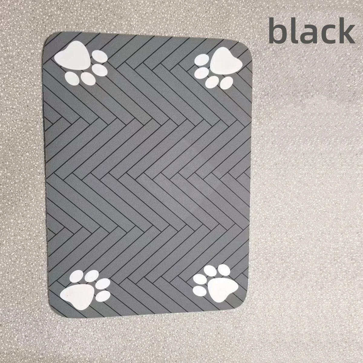 A black pet feeding mat with a gray chevron pattern and white paw prints.