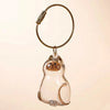 Figurine en verre clair de chat avec un cordon en cuir doré, utilisée comme porte-clés.