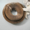 A cat is interacting with a round, accordion-style scratching board made of light brown material.