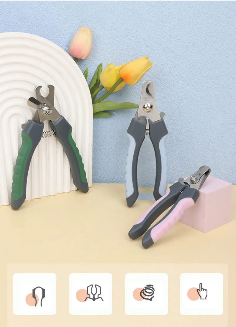 A collection of stainless steel pet nail clippers in various colors resting on a light surface.