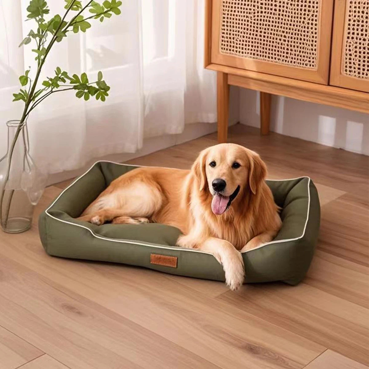 A golden retriever dog is lying on a green square dog bed indoors.