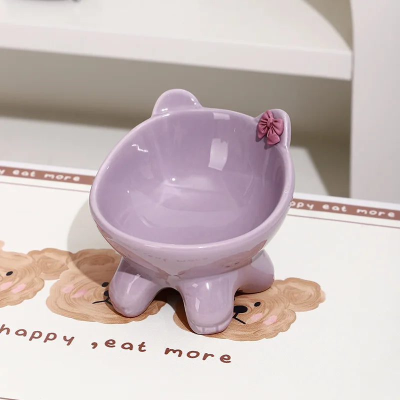 A light purple ceramic cat food bowl with a raised, tilted design resting on a white surface.