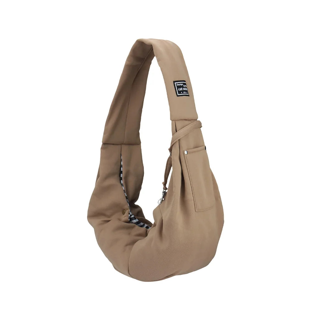 Beige tragbare Hundetasche mit Stoffriemen und kleinem schwarzem Etikett.