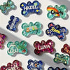 A collection of colorful silicone dog bone molds used for resin casting, featuring various glitter and colored designs.