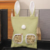 A light green fabric bag with rabbit ears and a hole, containing hay for small animals.