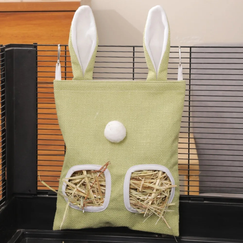 A light green fabric bag with rabbit ears and a hole, containing hay for small animals.