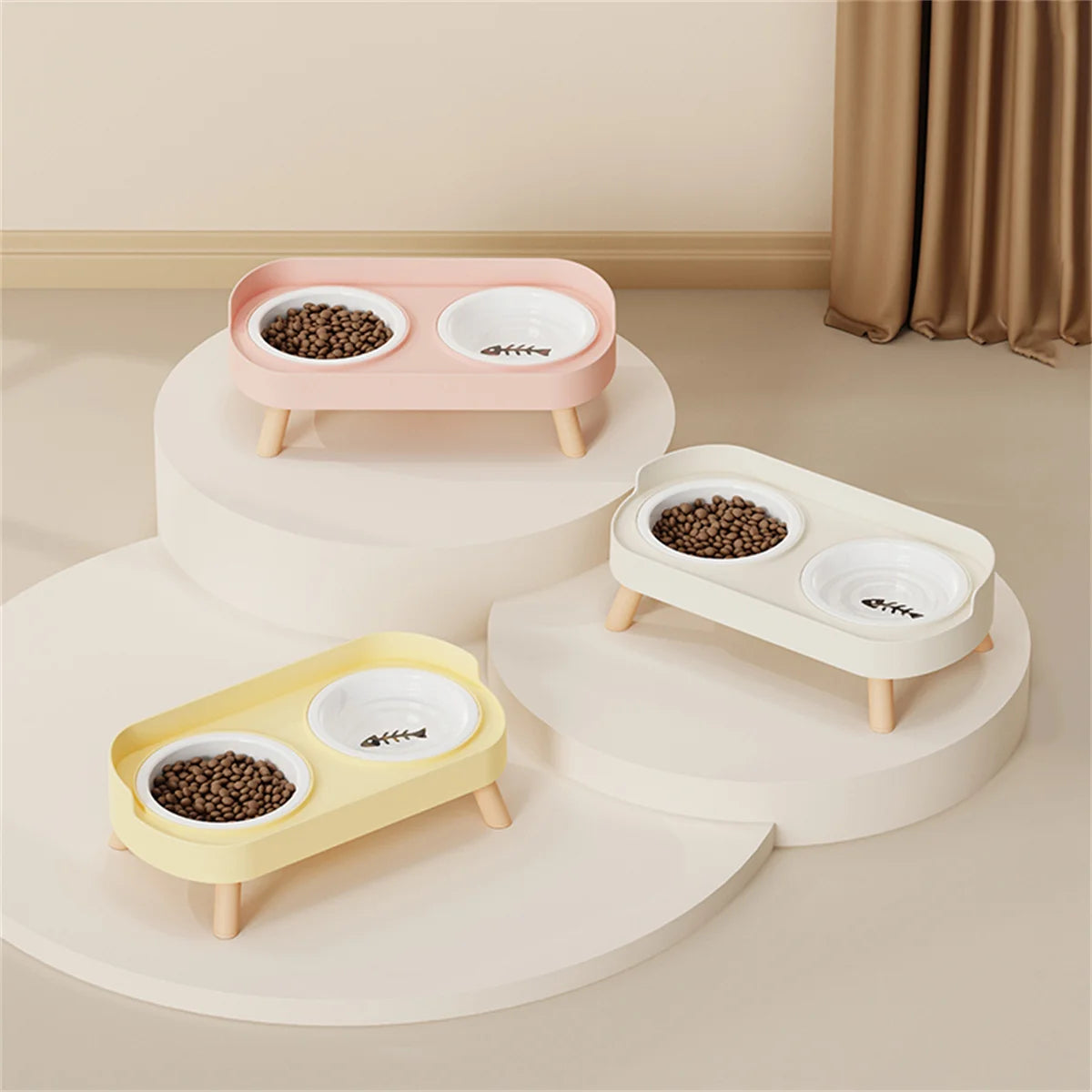 A set of three elevated ceramic pet bowls in pink, white, and yellow on round wooden stands.
