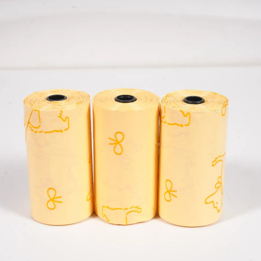 Three rolls of thick dog waste bags in yellow with mixed sweet patterns
