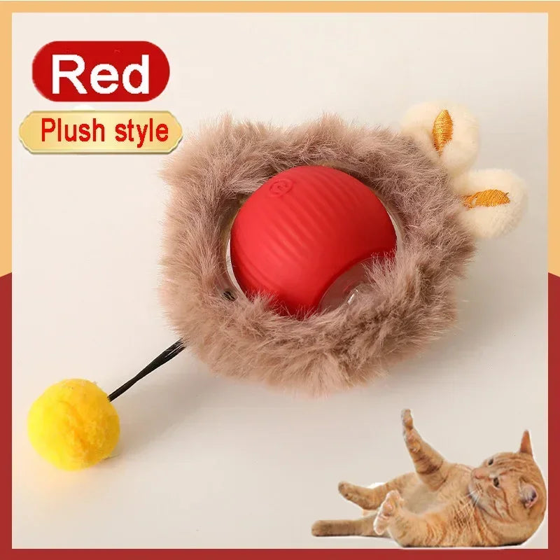 A red plush toy ball with a yellow accessory and a cat lying nearby.