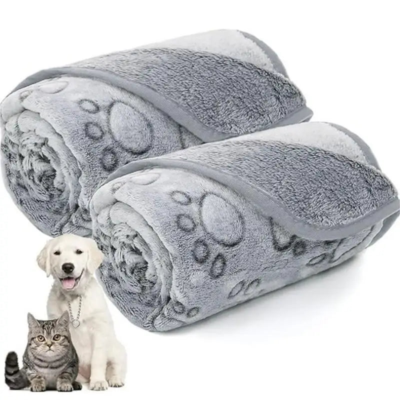 Une couverture en polaire de corail gris roulée, avec un chien et un chat visibles dessous.