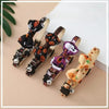 A collection of Halloween cat collars featuring various patterns, bows, and bells on leather straps.