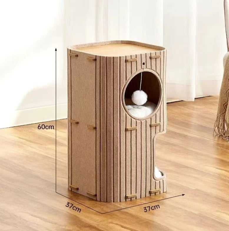 Casa de gato de madera marrón claro con entrada circular y una pelota peluda, sobre un suelo de madera.