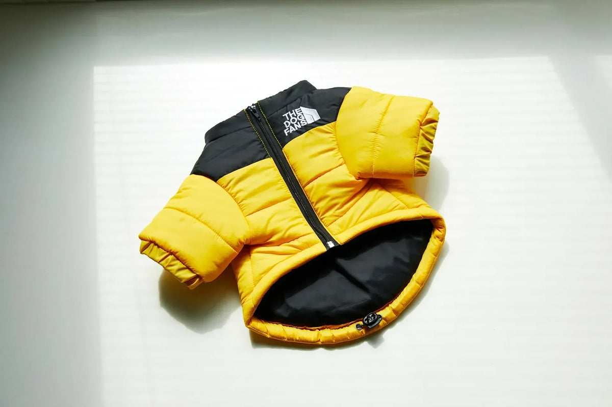 A yellow and black puffer coat for a dog, shown flat against a white background.