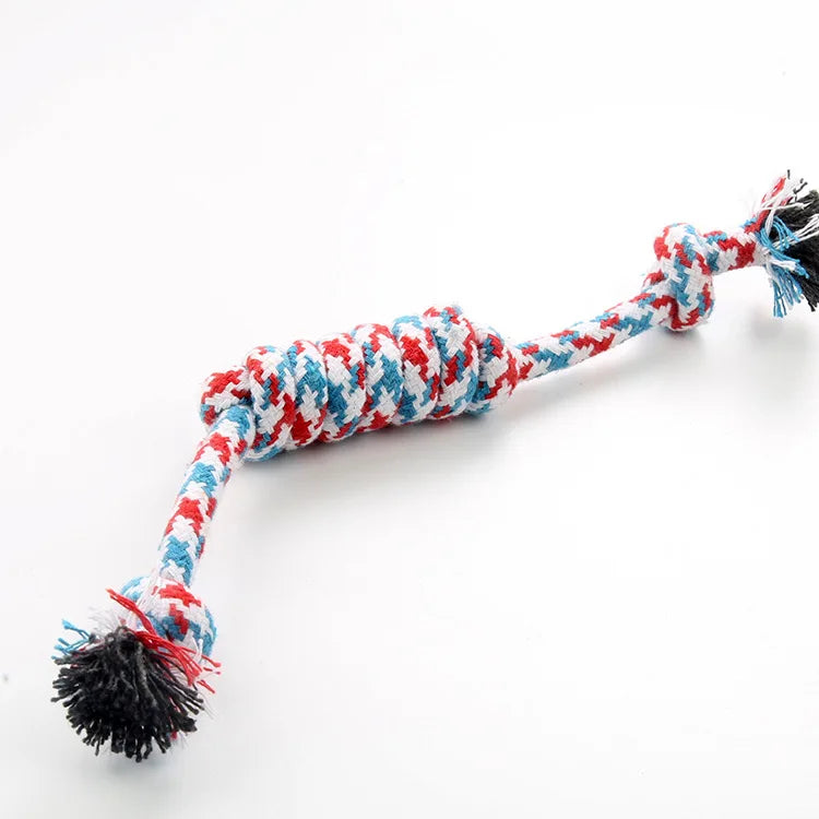 A braided cotton rope chew toy for dogs featuring red, white, and blue patterns with black tassels.
