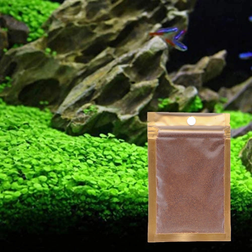A small pouch of black aquarium substrate gravel resting on bright green moss in an underwater display.