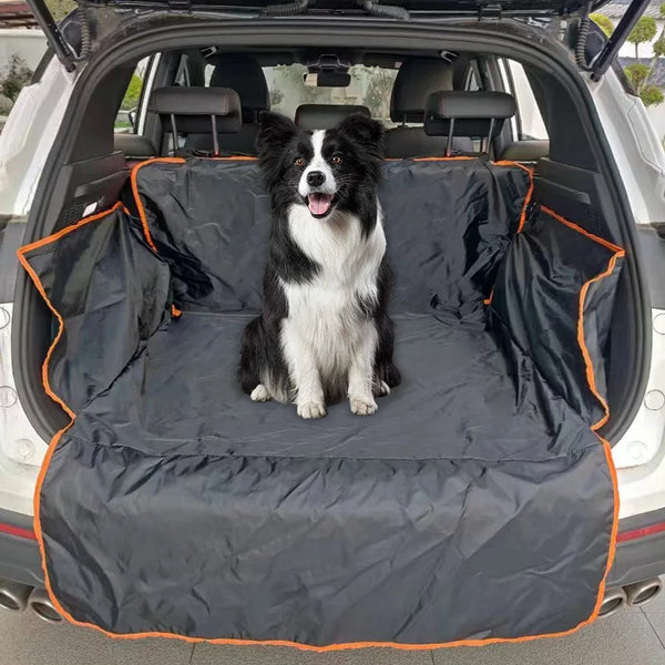 A black and white dog is sitting on a waterproof cargo liner inside the back of a white SUV.