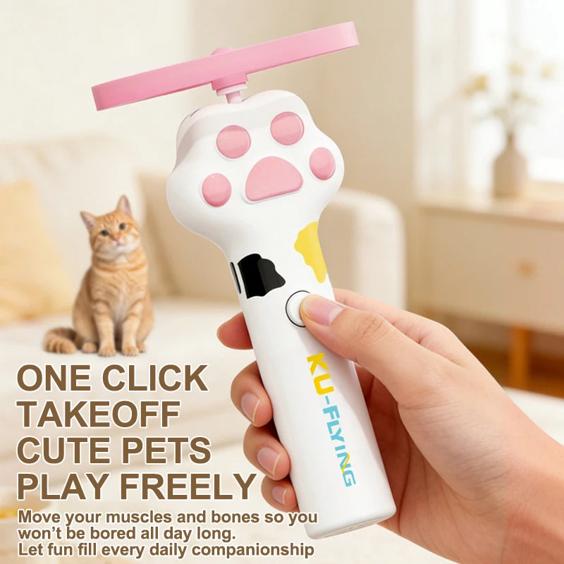 A hand holds a white interactive cat wand toy with a pink flying saucer attachment, demonstrating its use for pets.